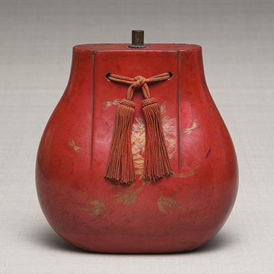 Treasure-bag shaped <i>sake</i> container<br /><span>vermillion lacquered. Shuri. Ryukyu Kingdom period, 18th to 19th century. 24.1×20.6cm.</span>